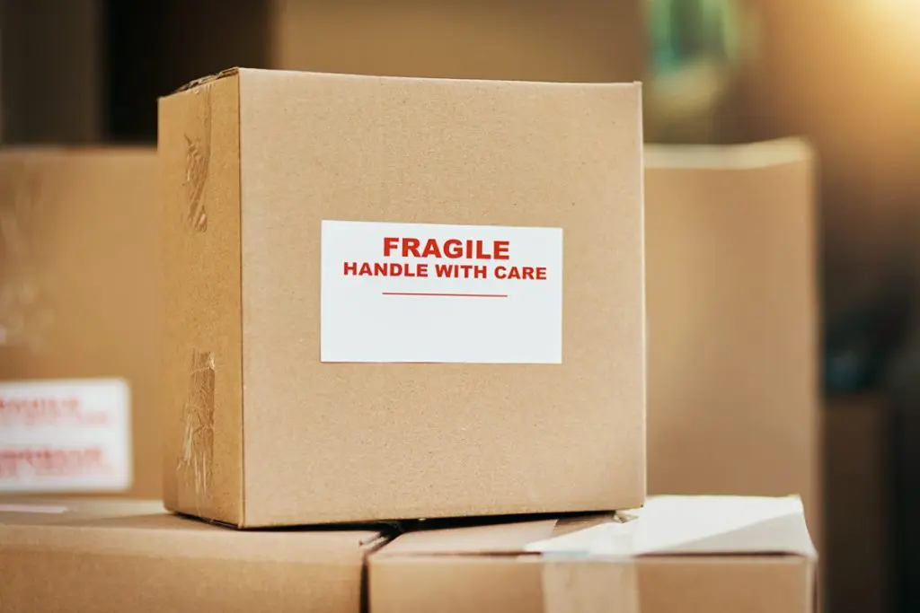 Box labeled with a fragile sticker, one of 12 packing tips for fragile items from Megan's Moving
