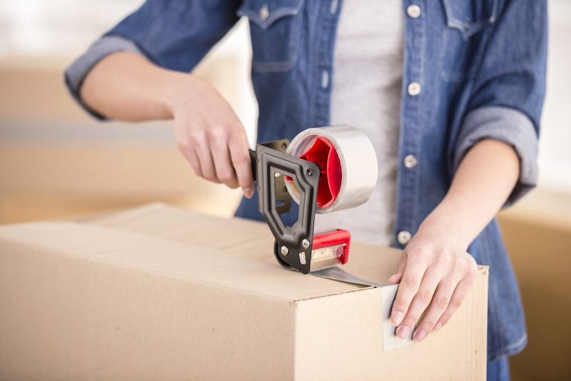 woman-in-denim-sealing-boxes-with-packaging-tape